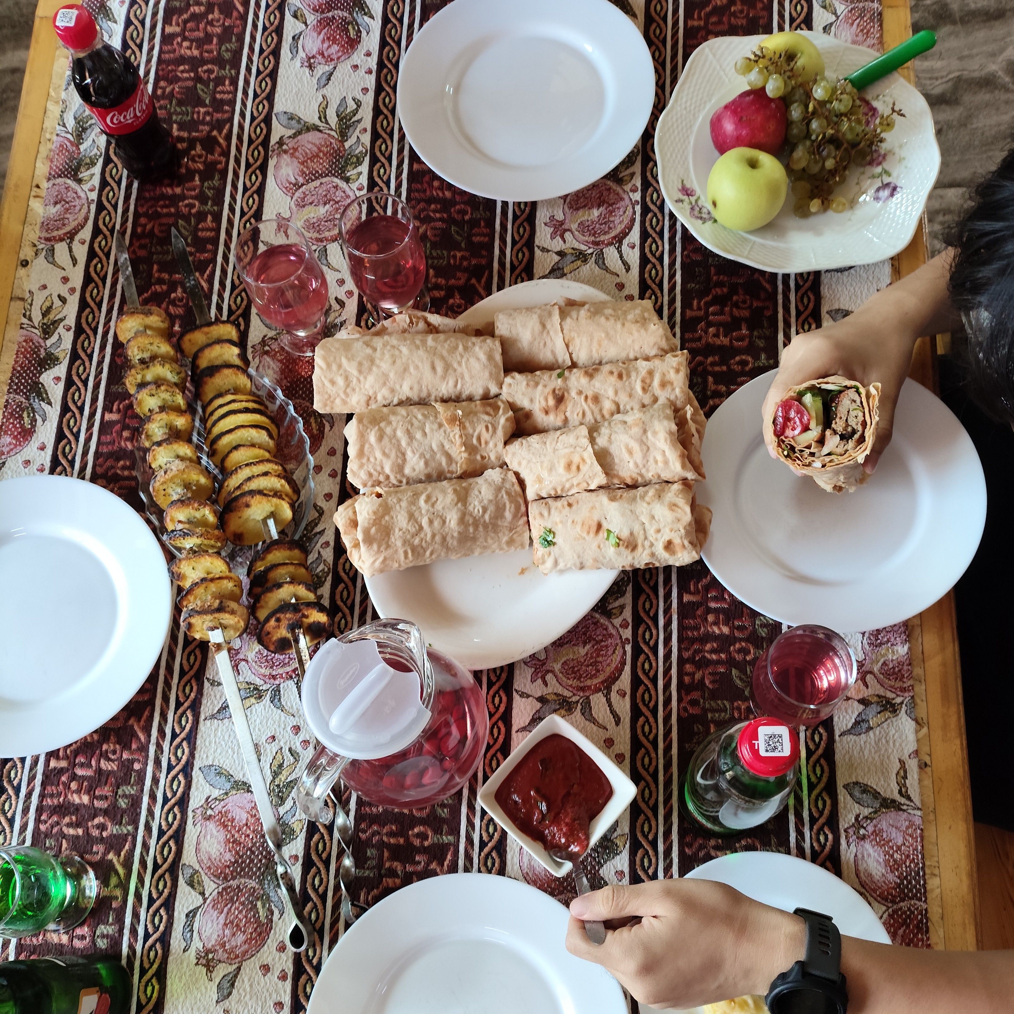 Spread of food: kebabs, potato, and fruits