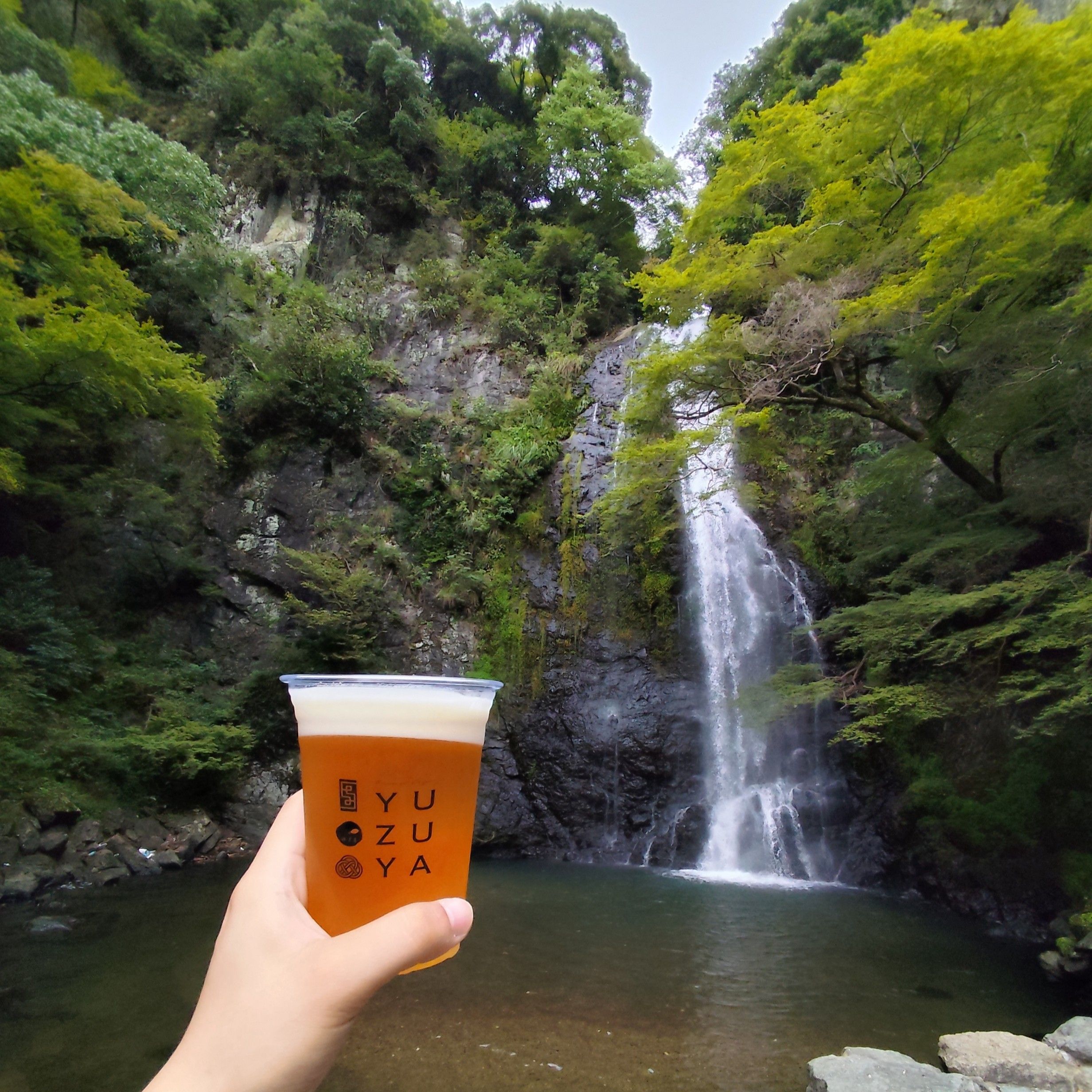 Holding a beer up to the falls